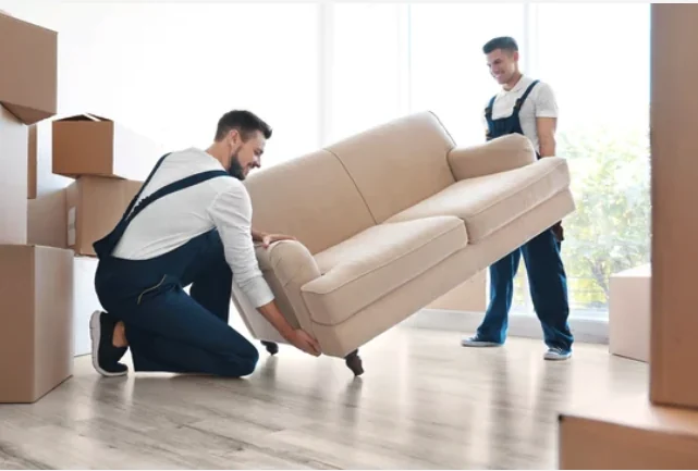 Professional moving crew handling a sofa