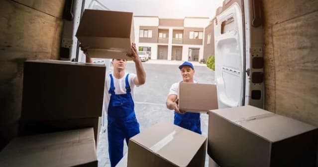 Movers carrying boxes toward a moving truck